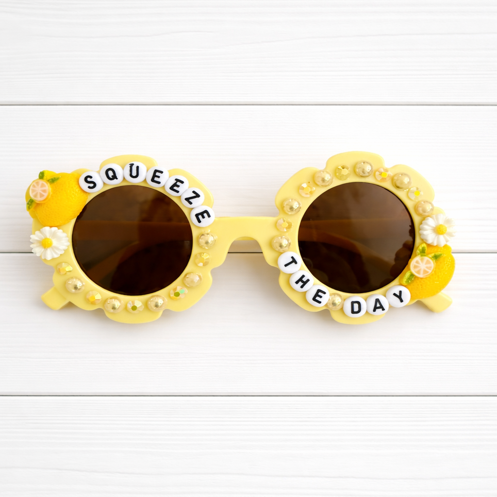 Kids flower yellow sunglasses with two lemon charms, yellow pearls and rhinestones outlining the frames, and "SQUEEZE THE DAY" text