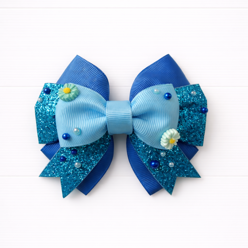 Blue glittery bow with floral charms on a white background