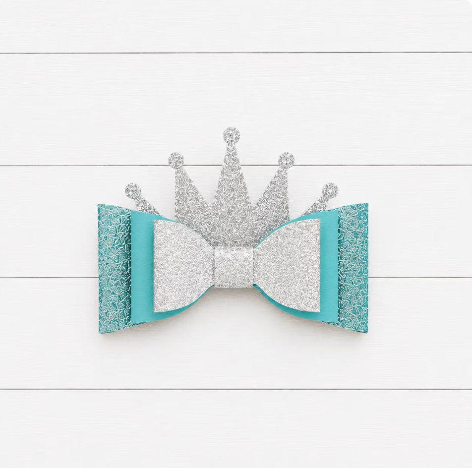Silver crown and turquoise bow on a white wooden background