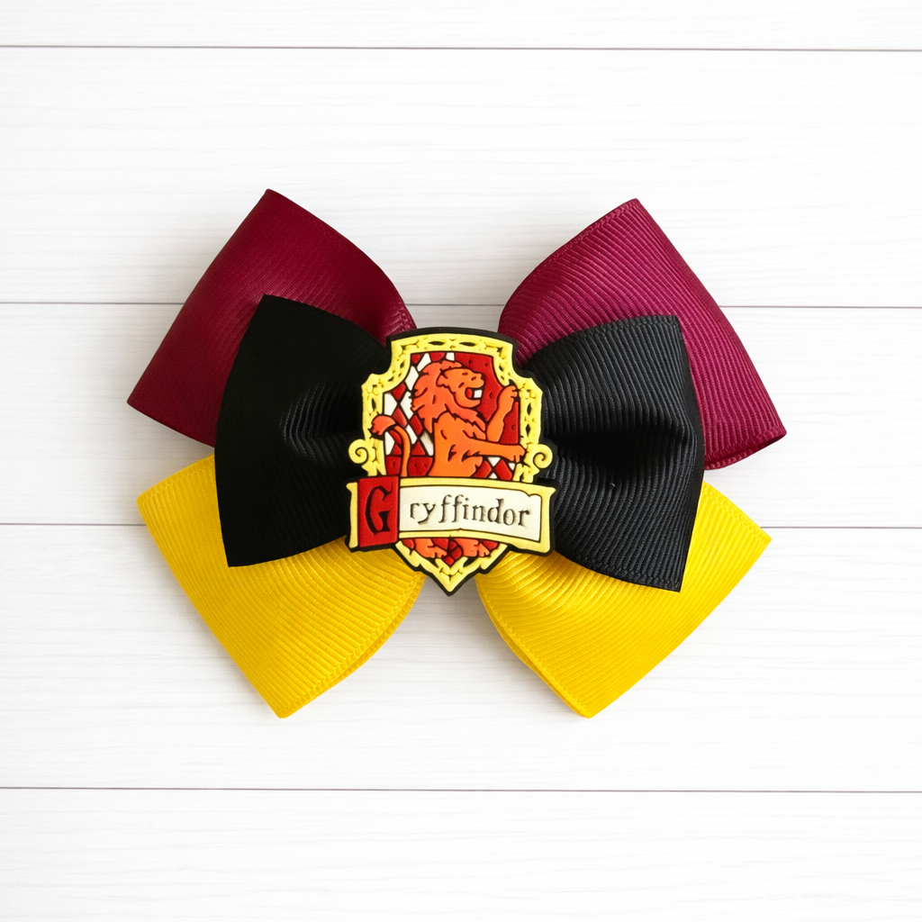 Red and yellow hair bow with Gryffindor house emblem on a white wooden background
