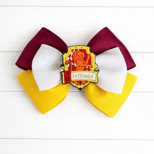 Red and yellow Hair bow with Gryffindor crest on a white wooden background