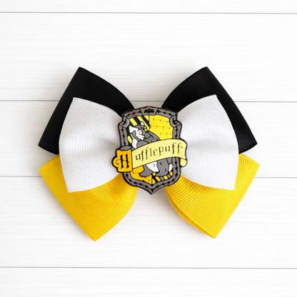Hufflepuff-themed hair bow with black, white, and yellow colors on a white wooden background