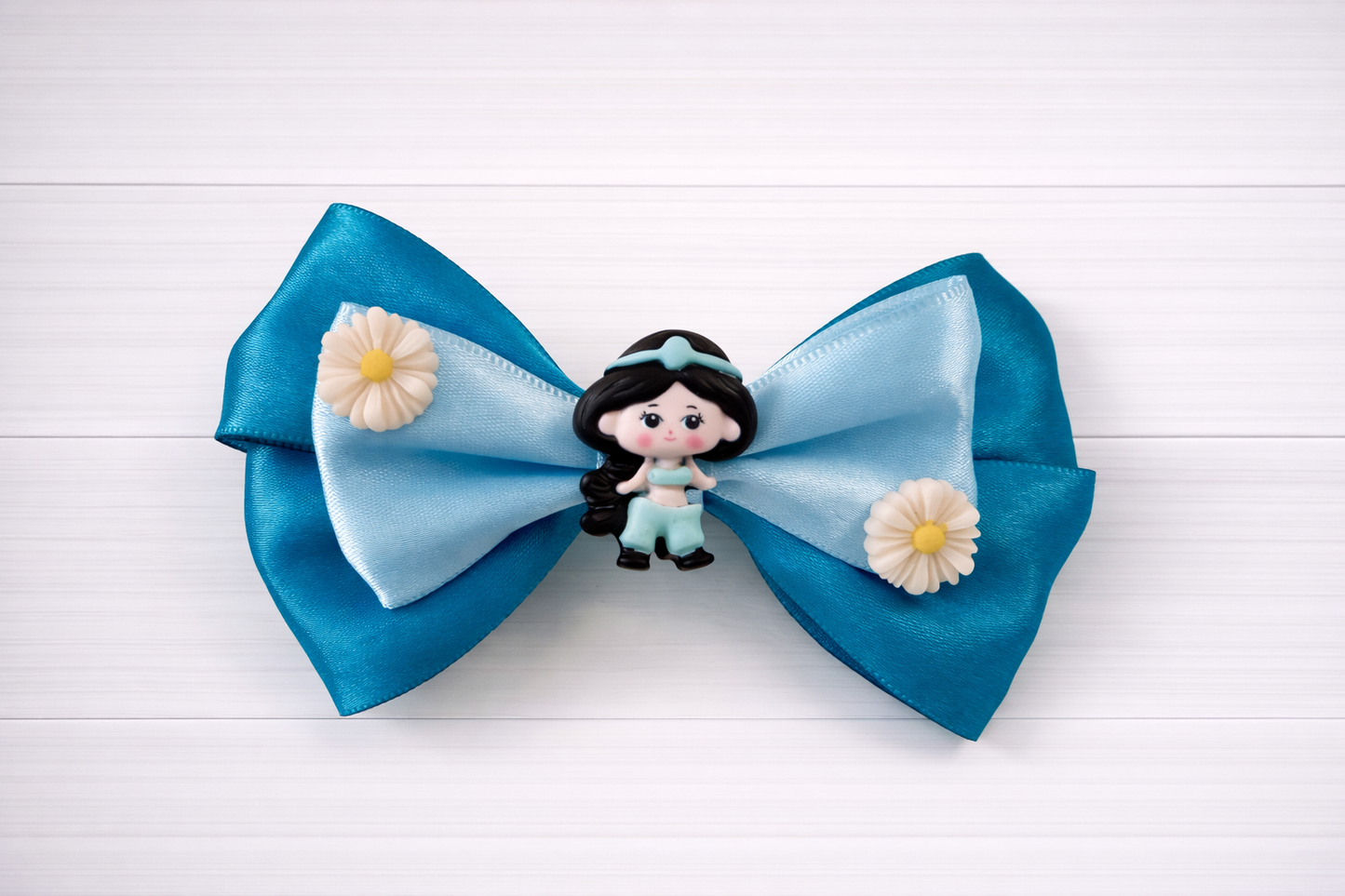 Large blue bow with a Jasmine charm in the middle and flowers on the sides