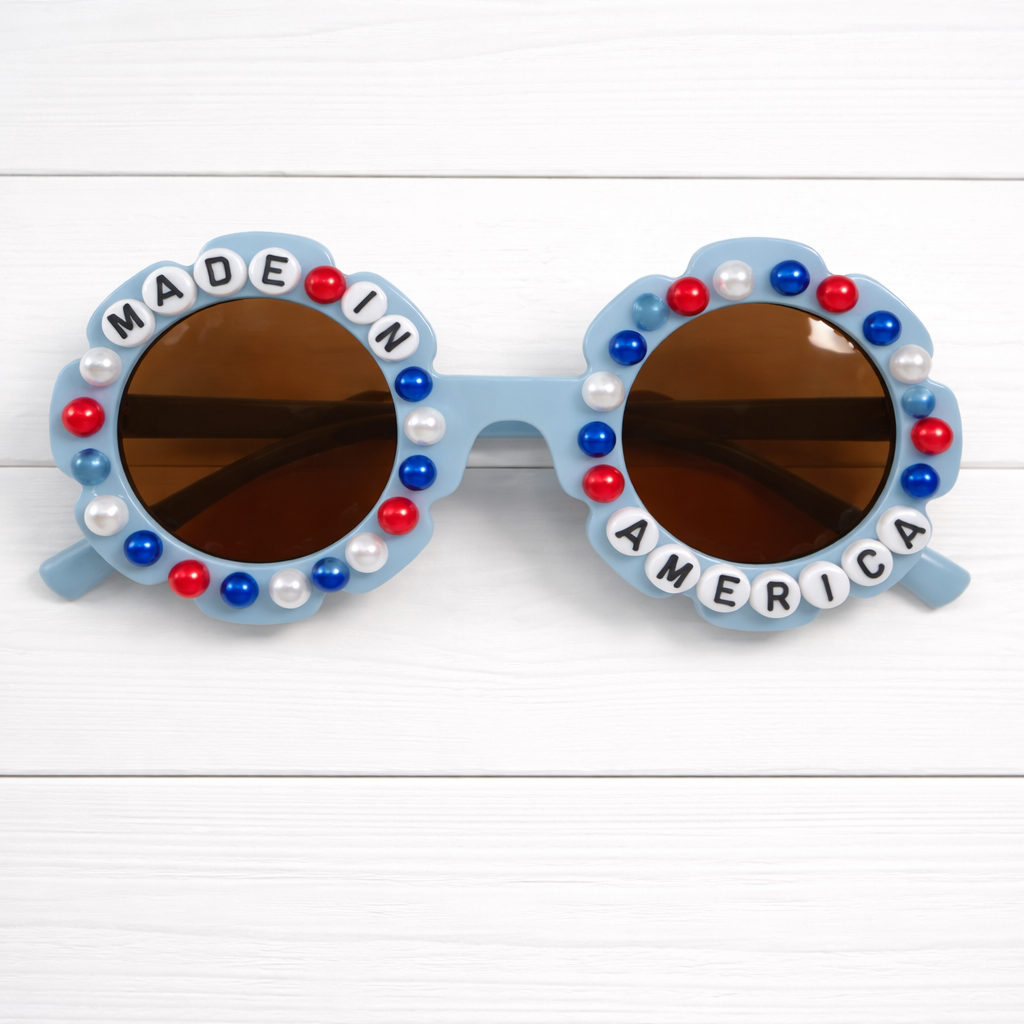Kids blue flower Sunglasses with 'Made in America' text and red, white, and blue pearls surrounding frame on a white background