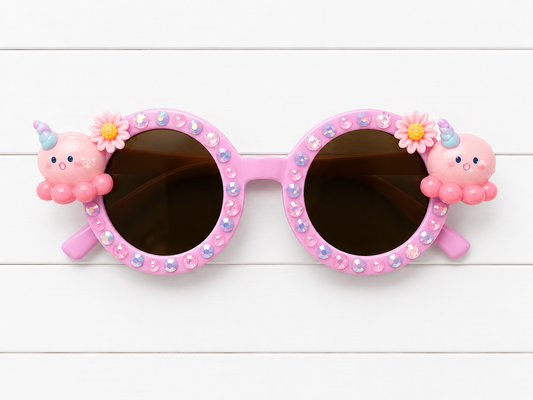 Kids round Pink sunglasses with octopus charms on both sides, blue and pink pearls and rhinestones outline the frames on a white background