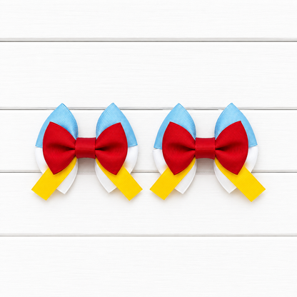 Two matching hair bows with light blue top, white bottom, red bow in the middle, and yellow tails
