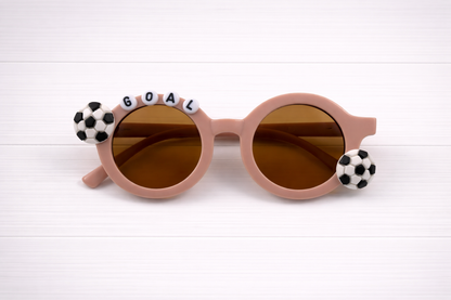 Kids grey sunglasses with two soccer charms and "GOAL" text outlining frame